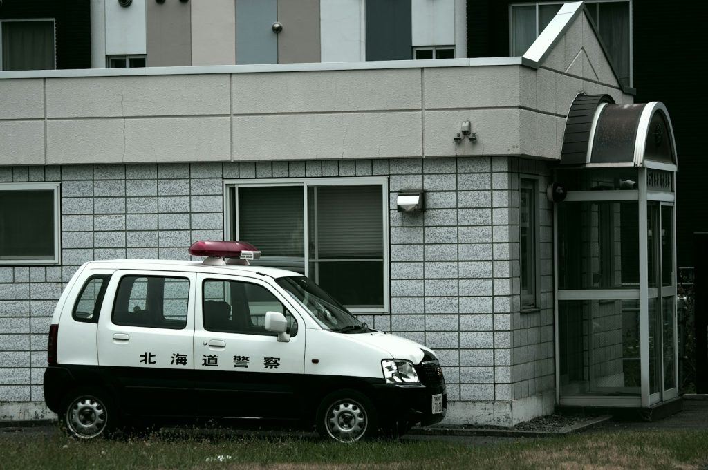 white and black volkswagen t-2 parked beside white concrete building during daytime